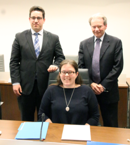  Trustee Waterfall takes her seat at the board table after signing the oath of office with Scott McMillan, chair of the board of trustees, and John Bryant, Director of Education.