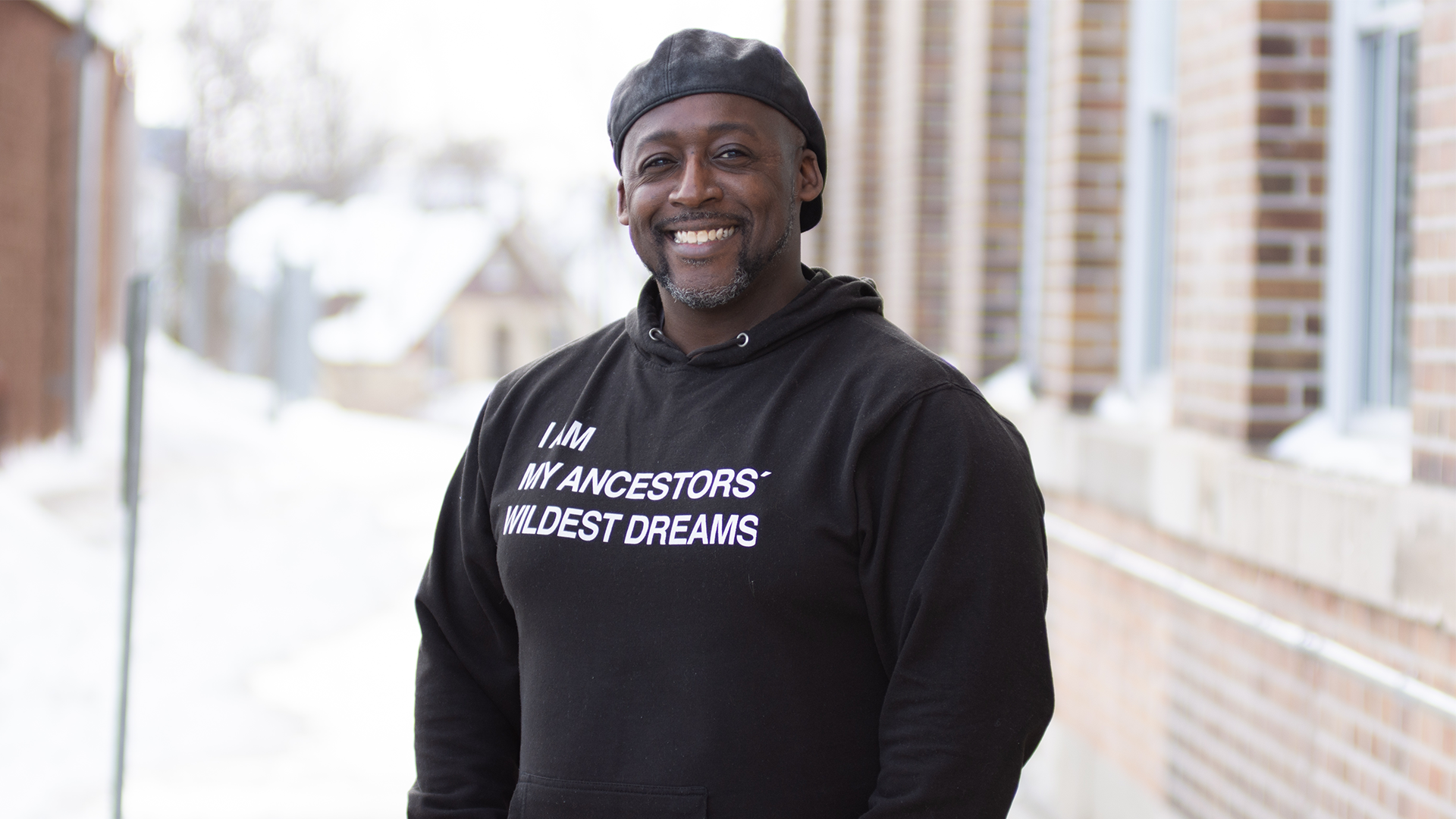 Photo of Chris Ashley. He is wearing a sweater that says "I am my ancestors' wildest dreams."