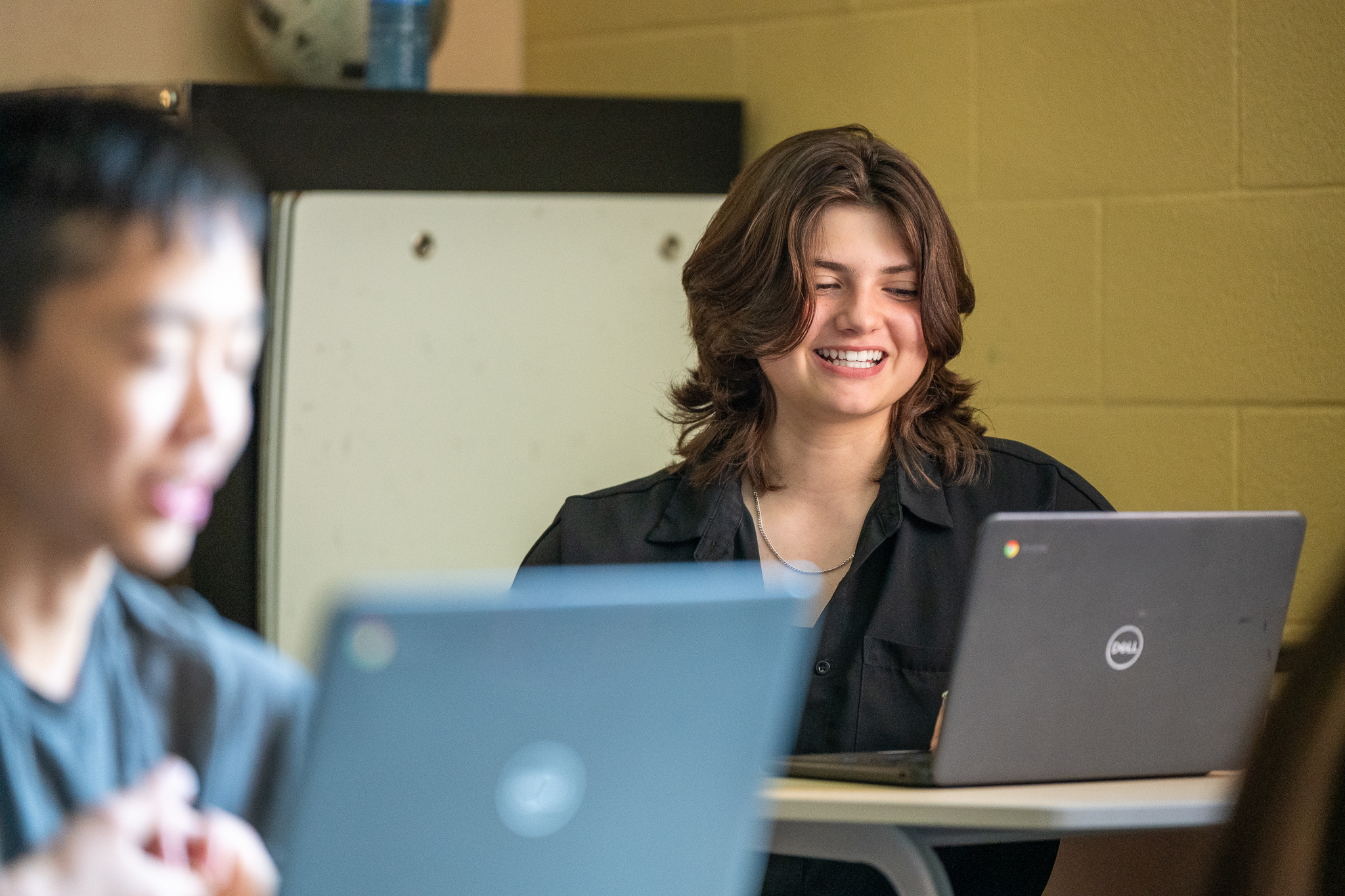 Student smiling at computer