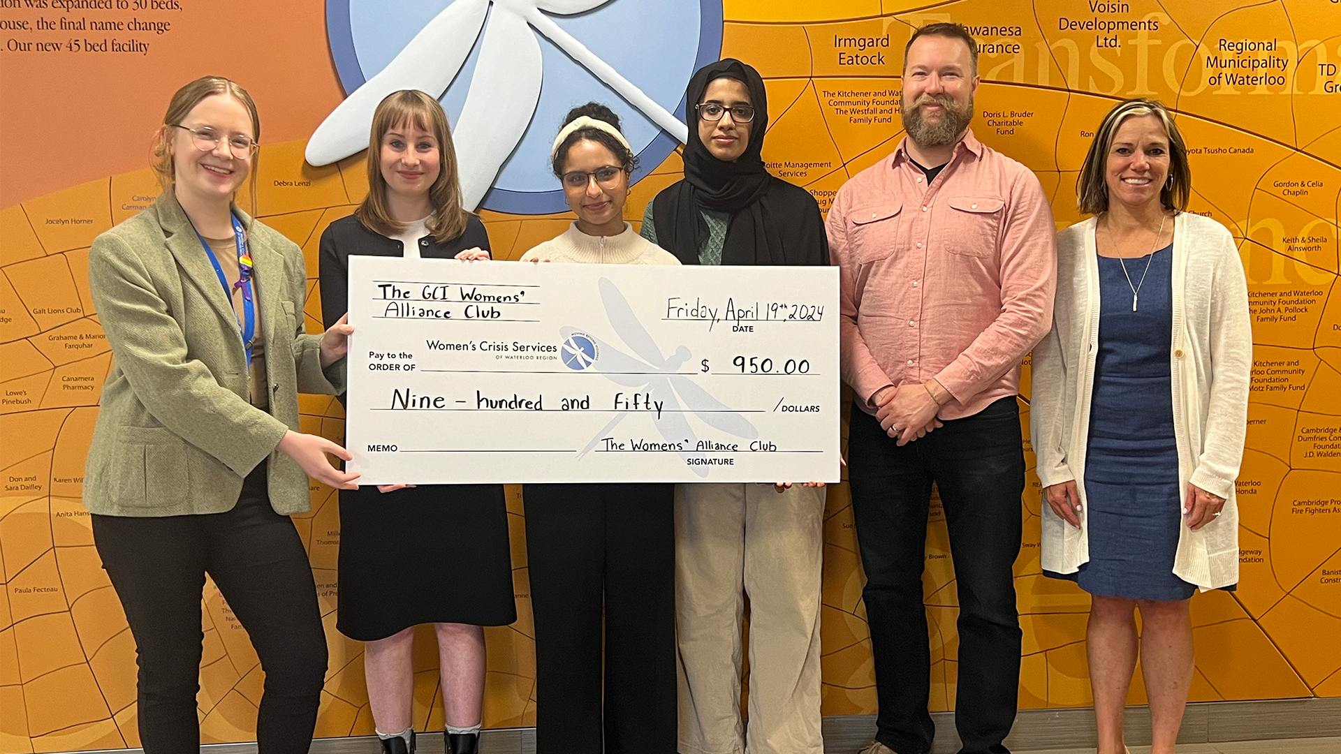 Students present a giant cheque for $950 to representatives from Haven House Women's Shelter.