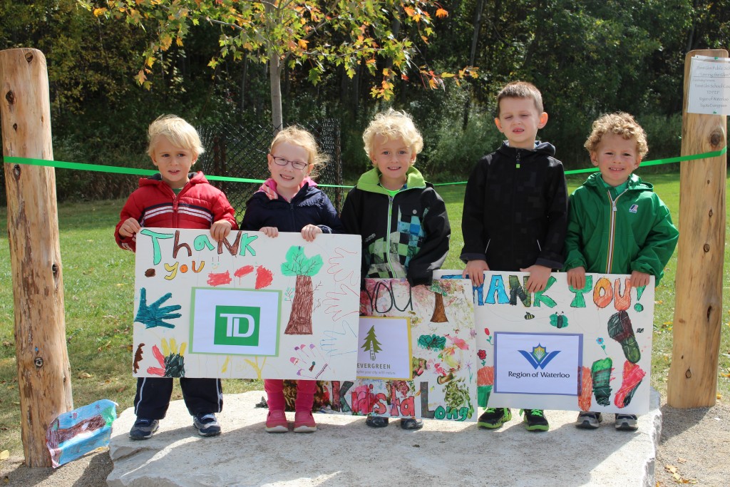 Students hold signs made to thank the sponsors of their new greening space.