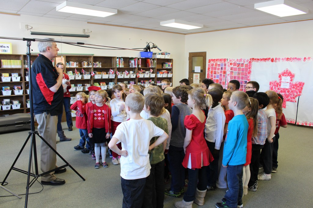 The students at King Edward PS gather around the microphone about to sing 'O Canada!'