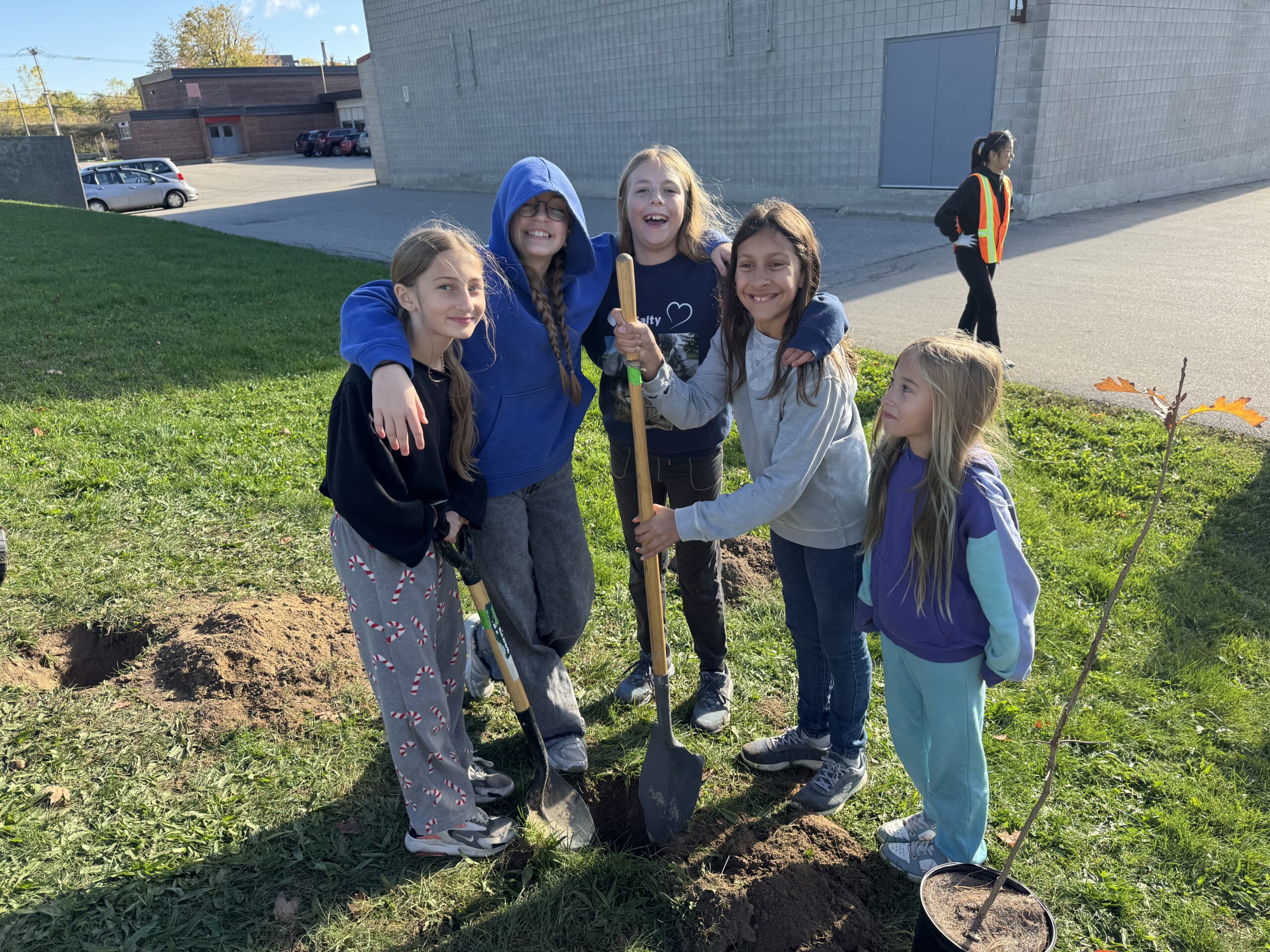 Students standing with shovel ready to plant trees
