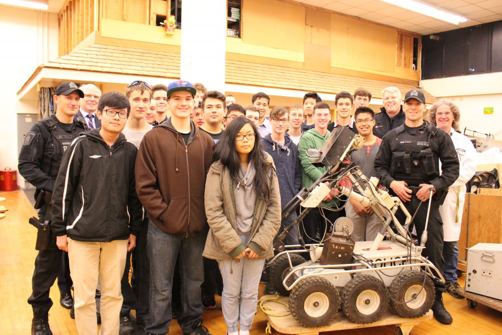 The tech class takes a group photo with their new robot, and WRPS officers.