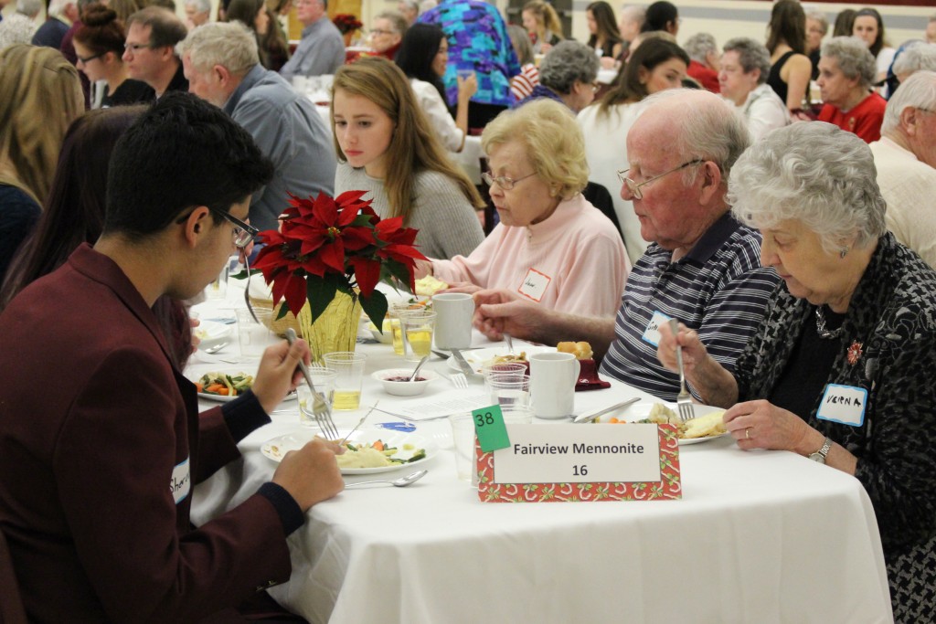 A table of students and seniors sharing stories and getting to know one another.