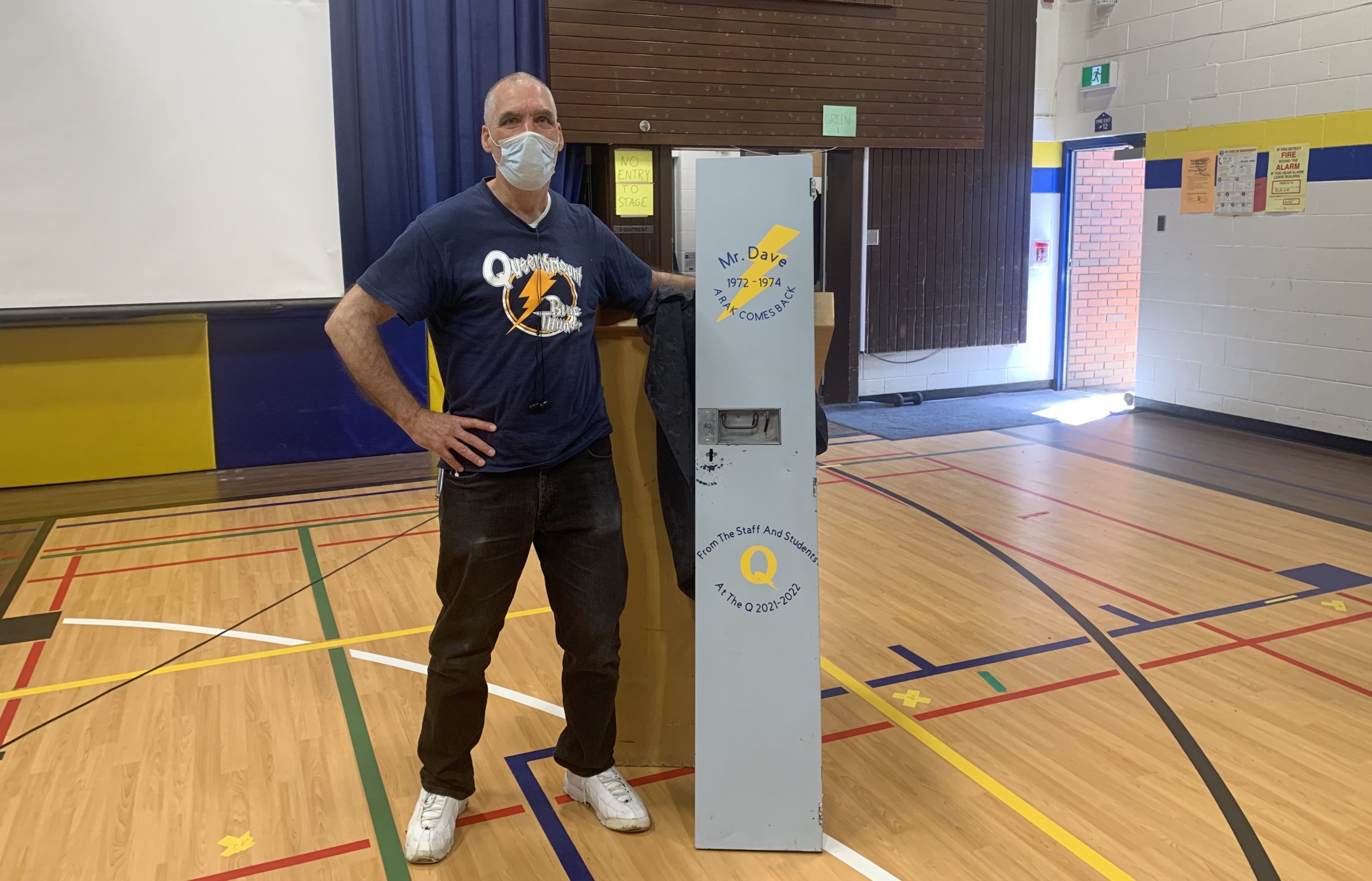 Mr. Dave stands with his locker door. It is painted with text that says "A RAK COMES BACK" and "Mr. Dave 1972 to 1974".