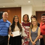 Gabrielle receives her award from Linda Fabi, with her family and Southwood SS staff.