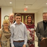 Kyle receives his award from Linda Fabi, with his family and staff from Grand River CI