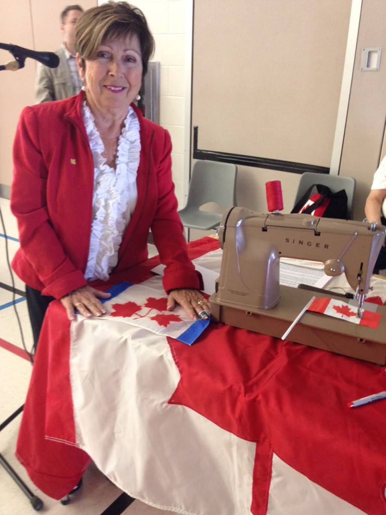 Joan O'Malley with her sewing machine, and Canadian flag.