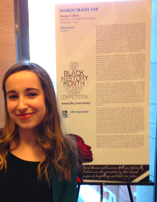 Award winner, Emma Cohen, standing in front of the poster with her essay.