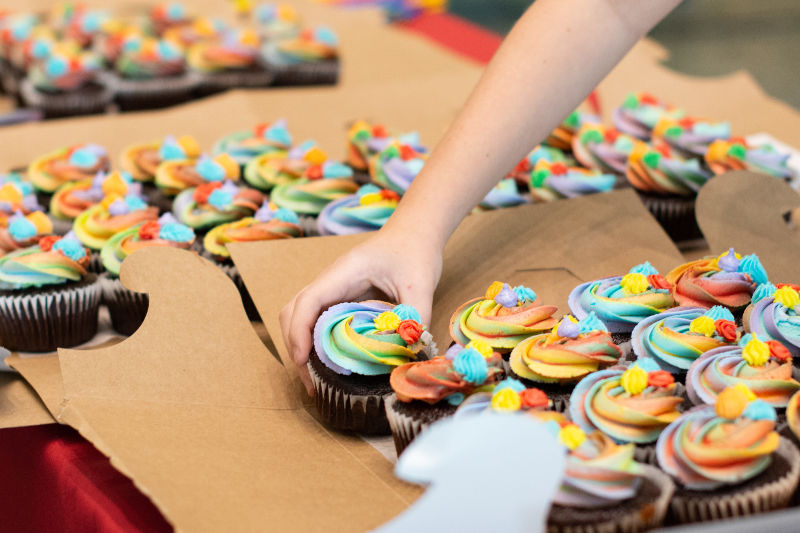 A student reaches for a Pride-themed cupcake following Kyne's talk.